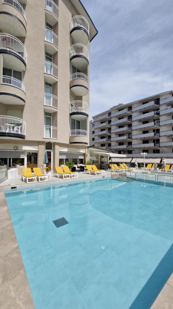 une grande piscine devant un immeuble dans l'établissement Hotel Stockholm, à Lido di Jesolo