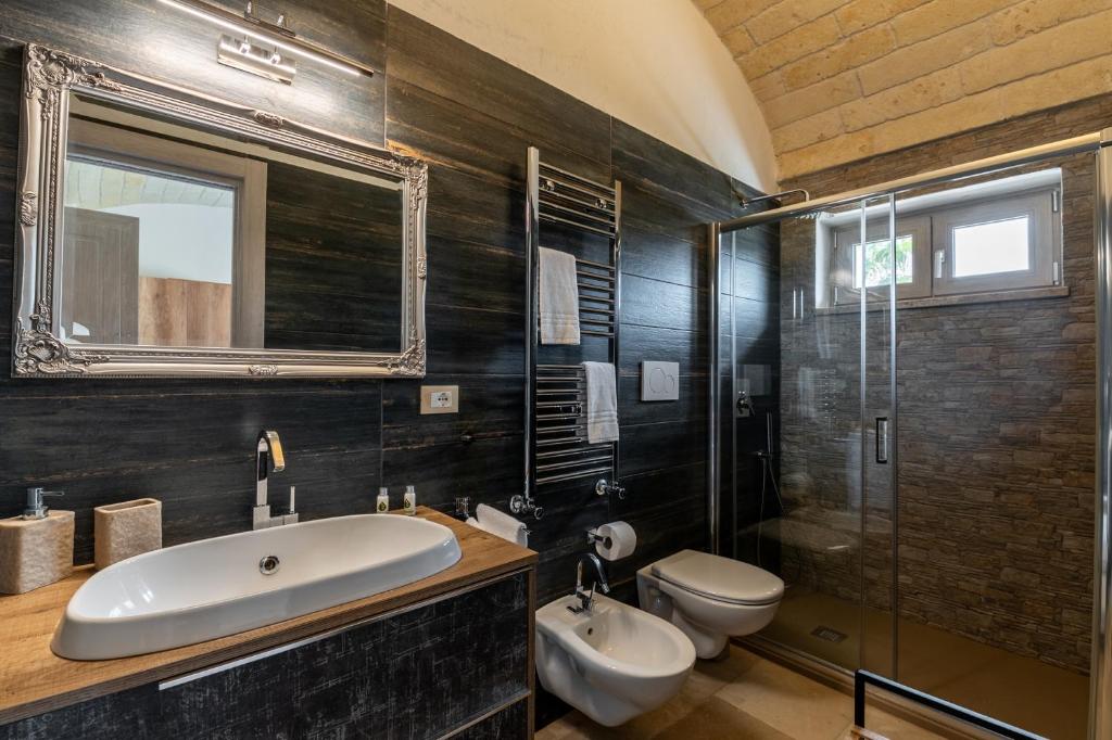 une salle de bain avec un lavabo, des toilettes et une douche dans l'établissement Villa Gli Arcangeli, à Ostuni