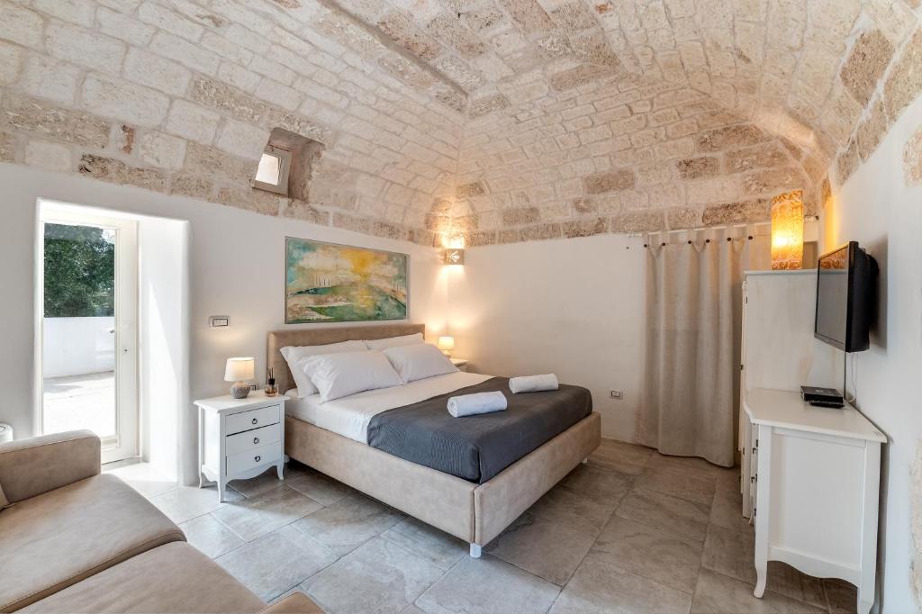 une chambre avec un lit, un canapé et une télévision dans l'établissement Villa Gli Arcangeli, à Ostuni 60 autres photos