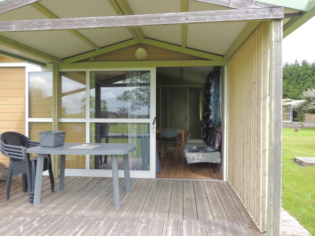 une pergola au-dessus d'une terrasse avec une table dans l'établissement CHALET 4 personnes maxi tout confort location en gîte, à Chazemais