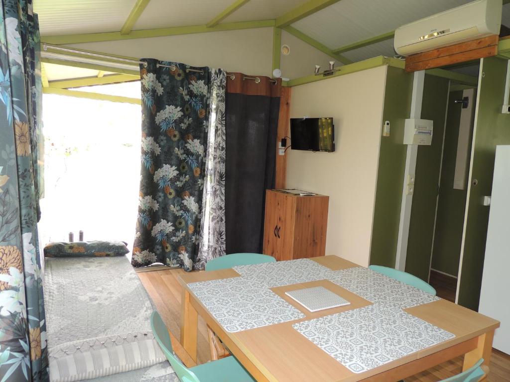 une table et des chaises dans une pièce avec une fenêtre dans l'établissement CHALET 4 personnes maxi tout confort location en gîte, à Chazemais