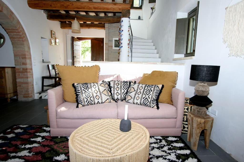 un salon avec un canapé rose et une table dans l'établissement Family friendly chic Italian farmhouse with pool, à Mogliano