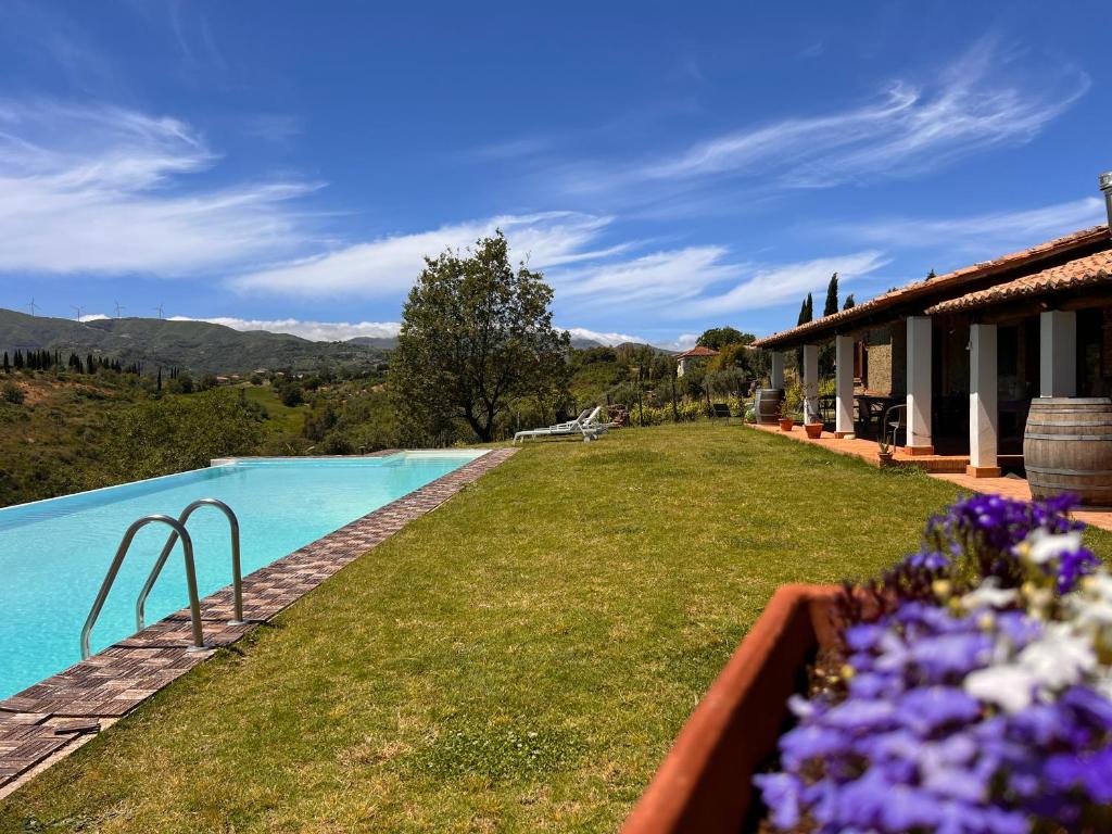 une maison avec une piscine ornée de fleurs violettes dans l'établissement Le quattro volte, à San Marco Argentano