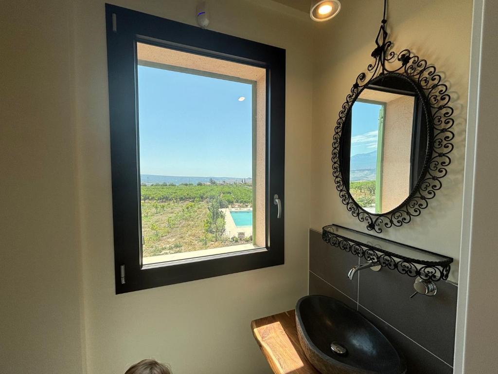 une salle de bain avec un lavabo noir et un miroir dans l'établissement Tenuta Coco, à Centuripe