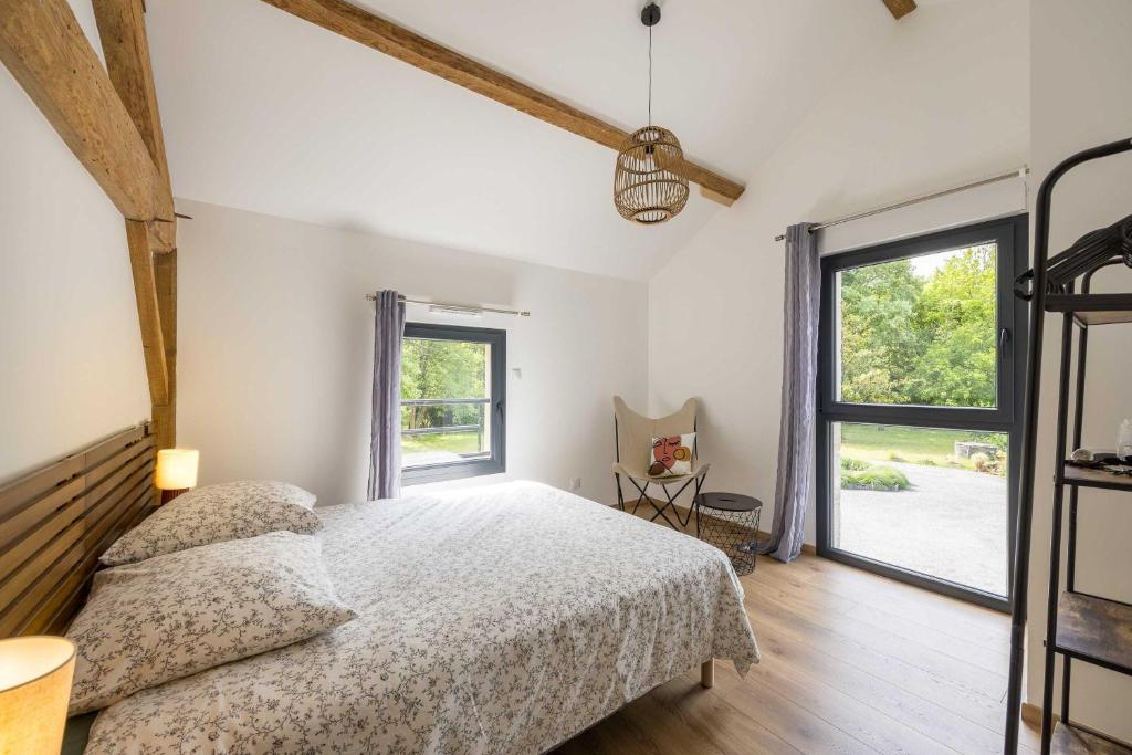 une chambre avec un lit et une grande fenêtre dans l'établissement Gîte de Lamourelle, à Lacquy
