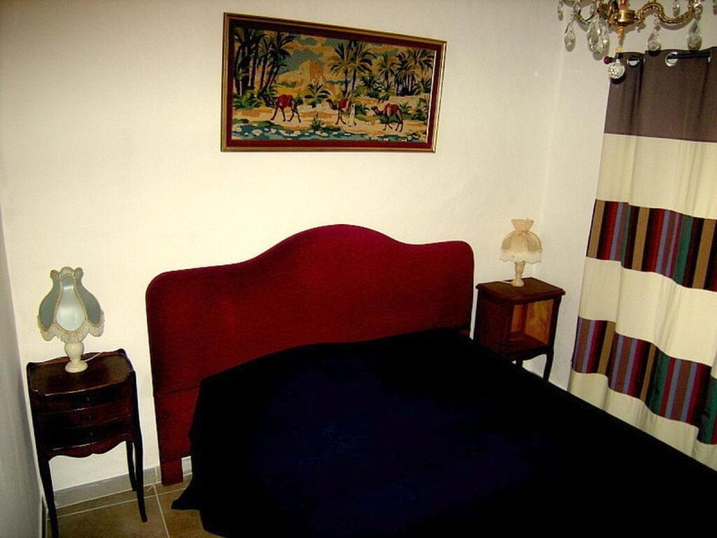 une chambre avec un lit rouge et deux tables de nuit dans l'établissement Maison Marianne Comfortable holiday residence, à Ferrals-lès-Corbières