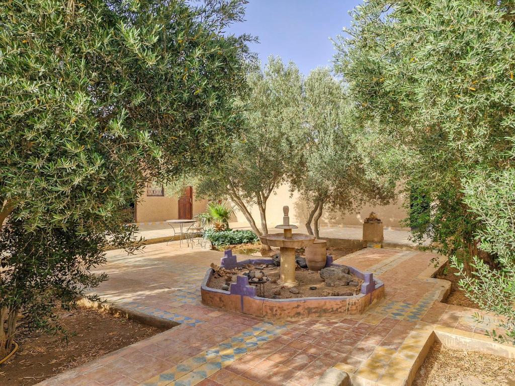 une fontaine au milieu d'une cour arborée dans l'établissement Riad Akour, à Merzouga