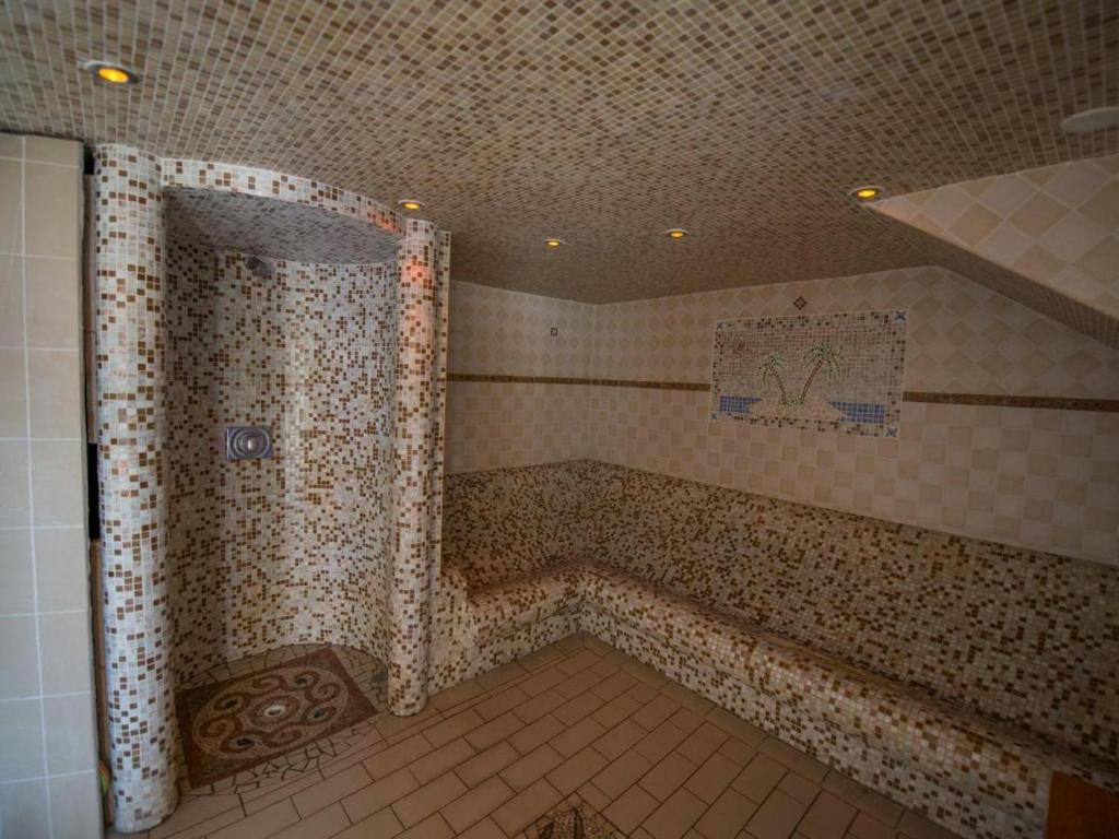 La salle de bains est pourvue d'une douche et d'un mur carrelé. dans l'établissement Mobil home 4 personnes climatisé, à Hyères