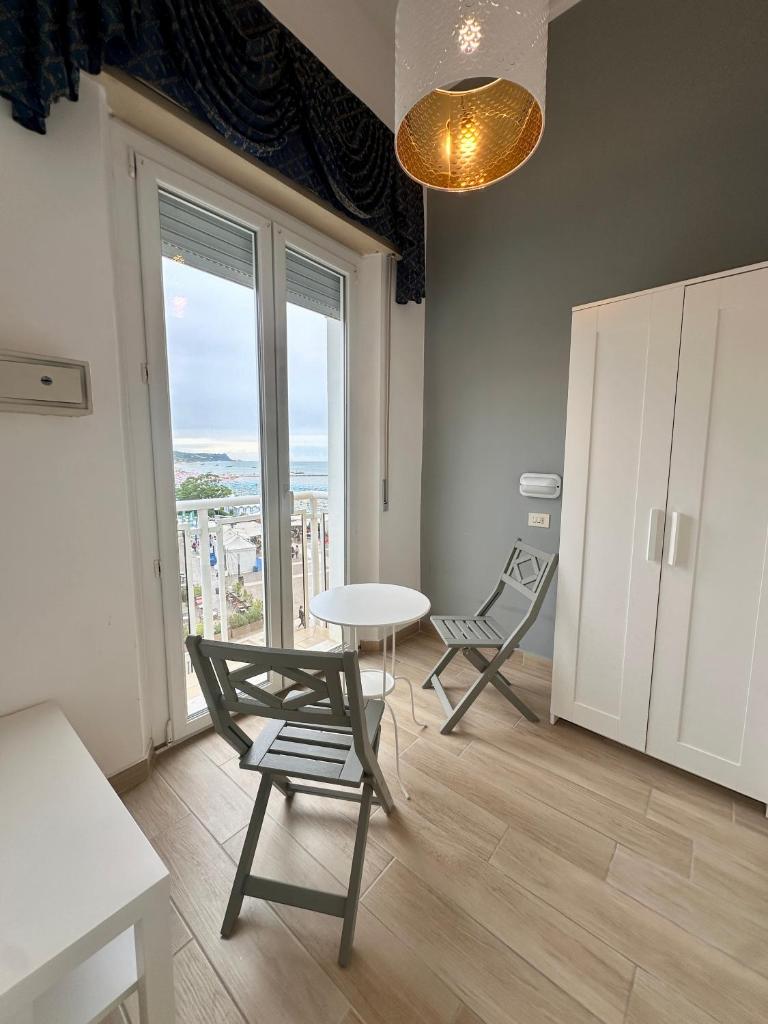 une pièce avec une table, des chaises et une fenêtre dans l'établissement Hotel Amelia, à Fano