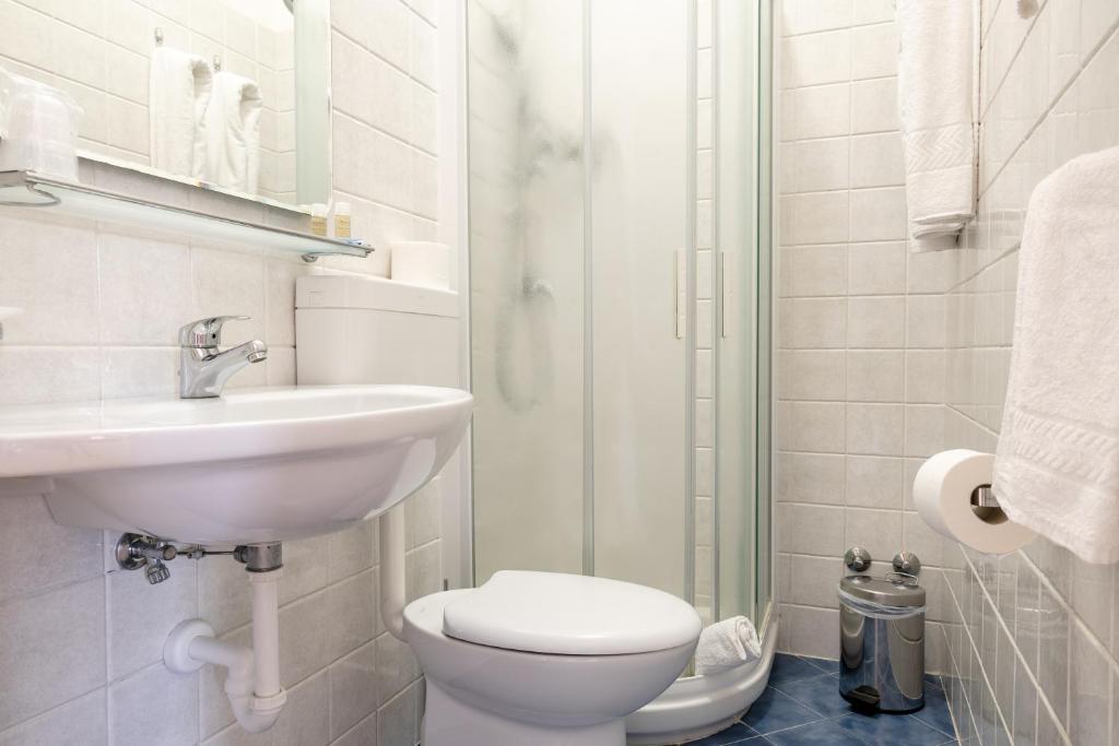 une salle de bain avec toilettes, lavabo et douche dans l'établissement Hotel Riviera, à Caorle