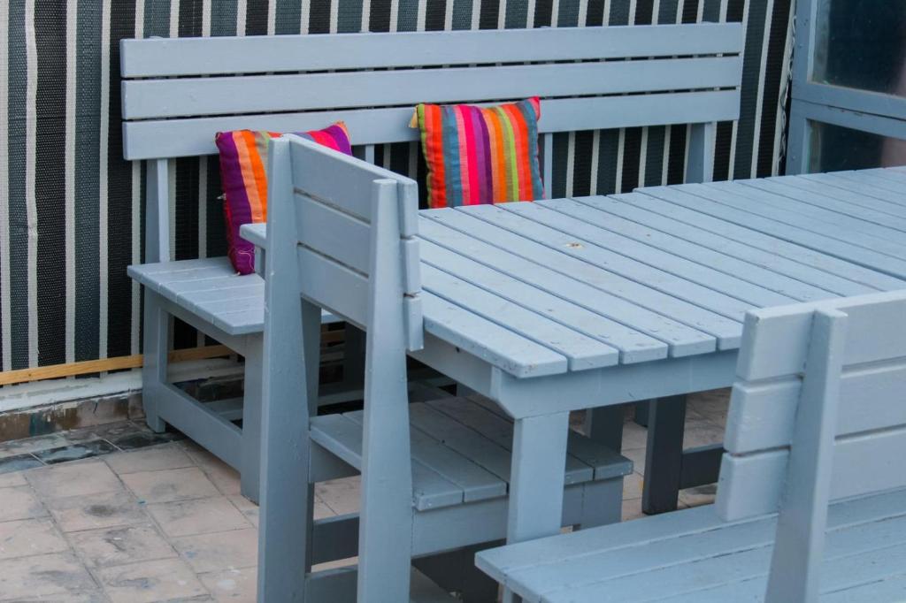 un banc blanc avec une table de pique-nique et un coussin coloré dans l'établissement Riad Darko, à Essaouira