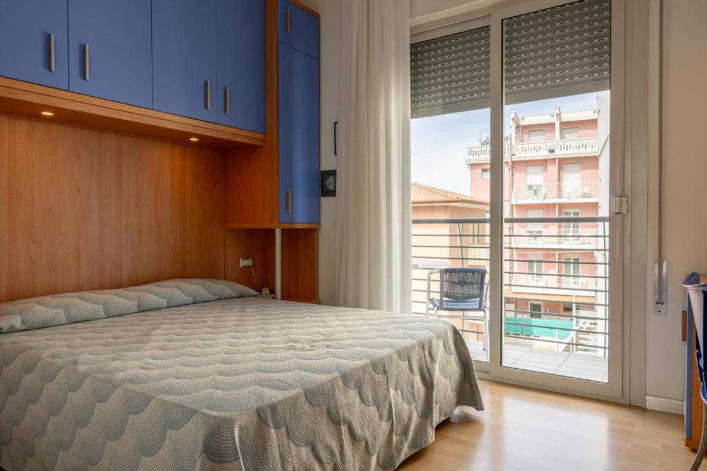 une chambre avec un lit et une grande fenêtre dans l'établissement Hotel Riviera, à Caorle
