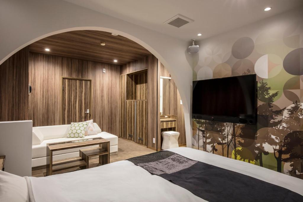 une chambre d'hôtel avec un lit et une télévision dans l'établissement Hotel Chroma - Adult Only, à Ueda