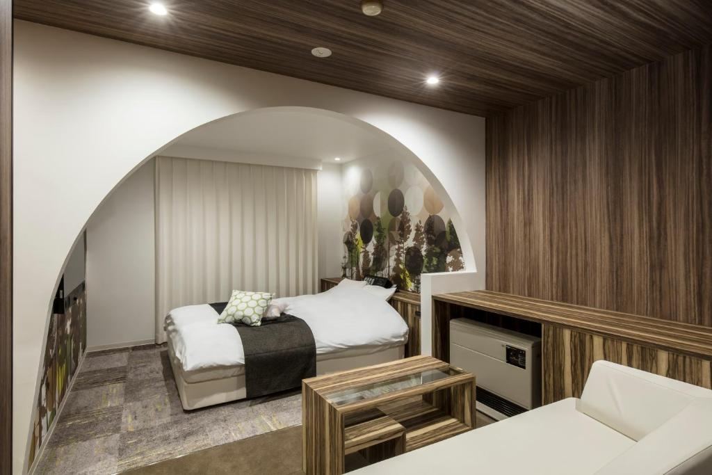 une chambre avec un lit et un canapé dans une pièce dans l'établissement Hotel Chroma - Adult Only, à Ueda