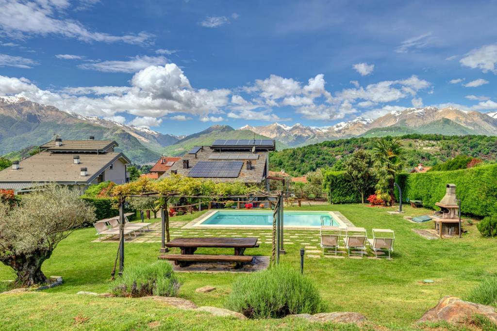 une maison avec une piscine et des montagnes en arrière-plan dans l'établissement Villa La Corte with amazing pool and garden, à Colico