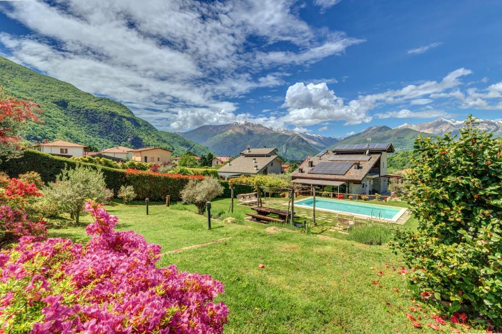 un jardin avec une piscine et des montagnes en arrière-plan dans l'établissement Villa La Corte with amazing pool and garden, à Colico