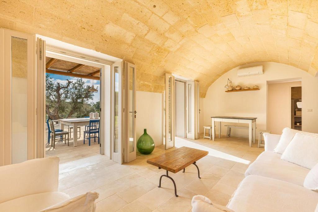 un salon avec un canapé blanc et une table dans l'établissement Salento Urbes Collection, à Marina di Pescoluse