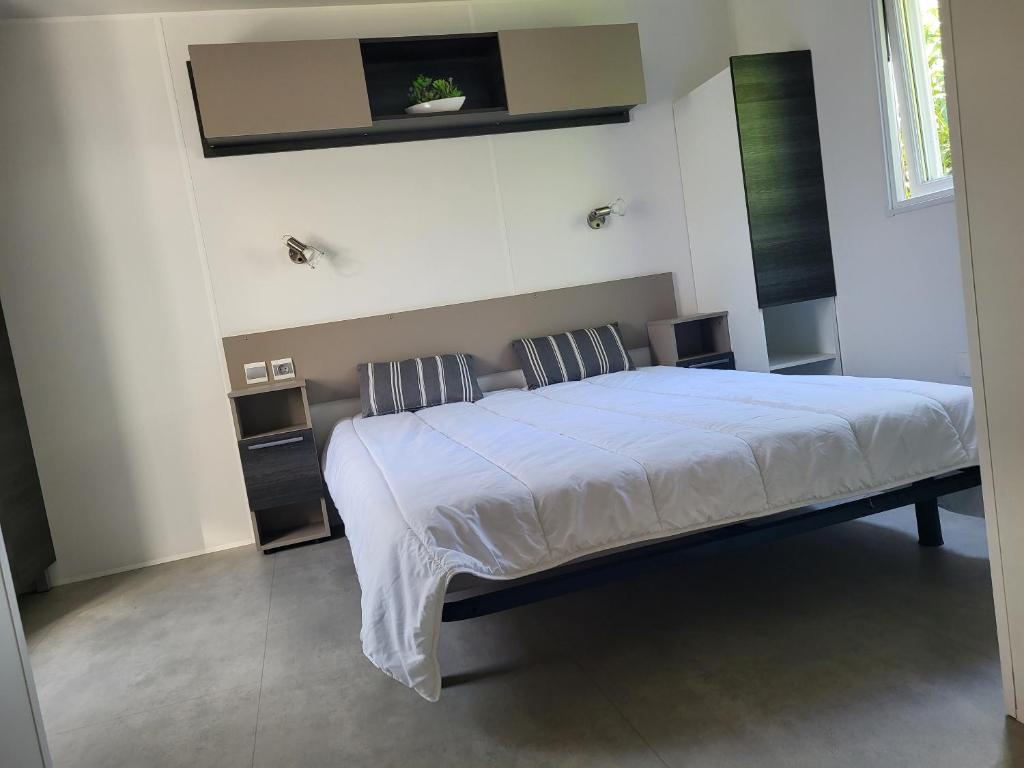 une chambre avec un grand lit avec des draps blancs dans l'établissement Fabuleux mobil-homme 4/6 personnes, à Fréjus 27 autres photos