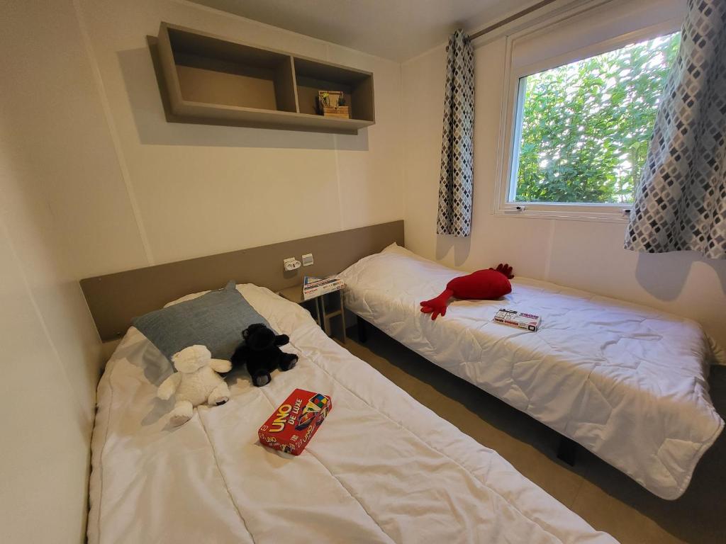 2 lits avec des animaux farcis dans une pièce dans l'établissement Fabuleux mobil-homme 4/6 personnes, à Fréjus