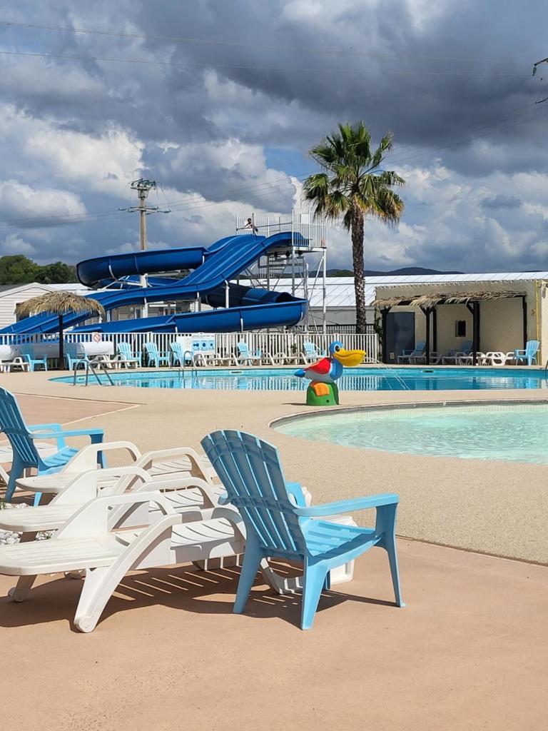 une piscine avec des chaises et un parc aquatique dans l'établissement Fabuleux mobil-homme 4/6 personnes, à Fréjus