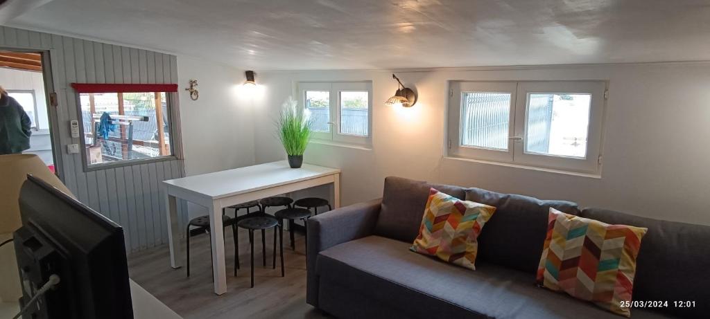 un salon avec un canapé et une table dans l'établissement Mobil home 6 pers - camping Les Arbouses - clim terrasse plancha, au Castellet