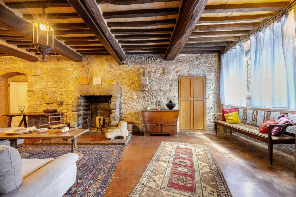 un salon avec une cheminée et un mur en pierre dans l'établissement Villa Campo di Fiore, à Arezzo