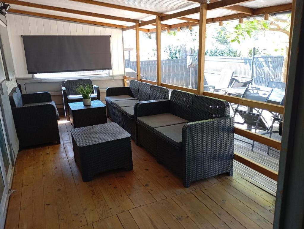 un porche grillagé avec des canapés et un écran de projection dans l'établissement Mobil home 6 pers - camping Les Arbouses - clim terrasse plancha, au Castellet