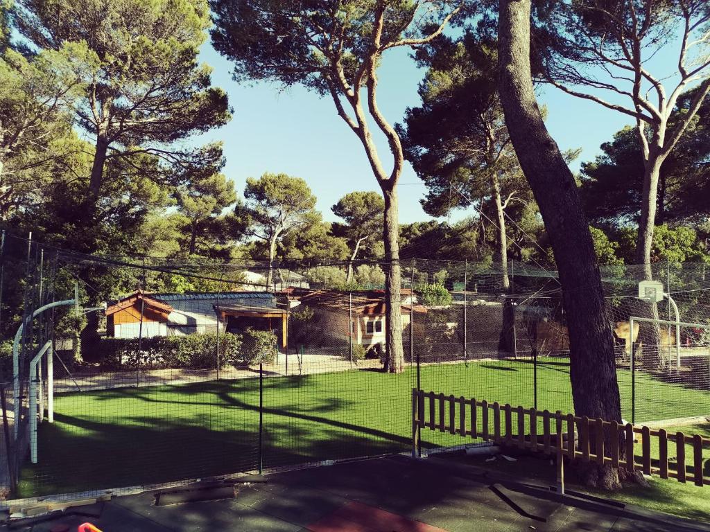 une maison avec un court de tennis dans une cour dans l'établissement Mobil home 6 pers - camping Les Arbouses - clim terrasse plancha, au Castellet