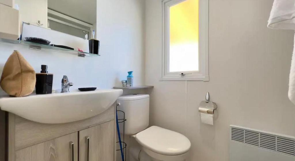 une salle de bain blanche avec un lavabo et des toilettes dans l'établissement CAMPING Siblu Le Montourey - LE FARNIENTE, à Fréjus