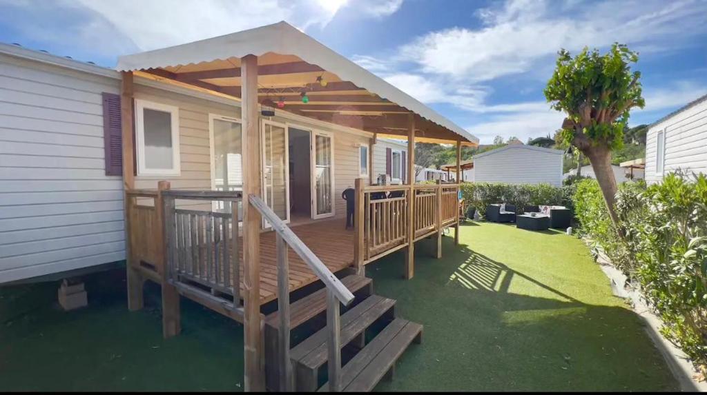 une maison avec une terrasse en bois et un kiosque dans l'établissement CAMPING Siblu Le Montourey - LE FARNIENTE, à Fréjus