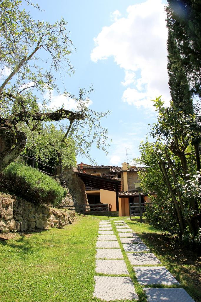 un jardin avec un chemin en pierre menant à un bâtiment dans l'établissement Tuscany Villa Chianti Hills - Villa Oliveta, à Loro Ciuffenna