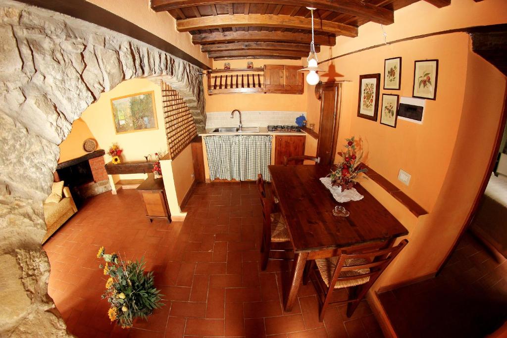 une cuisine et une salle à manger avec une table et un mur en pierre dans l'établissement Tuscany Villa Chianti Hills - Villa Oliveta, à Loro Ciuffenna