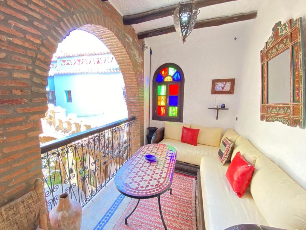 un salon avec un canapé et une fenêtre dans l'établissement Riad Gharnata, à Chefchaouen