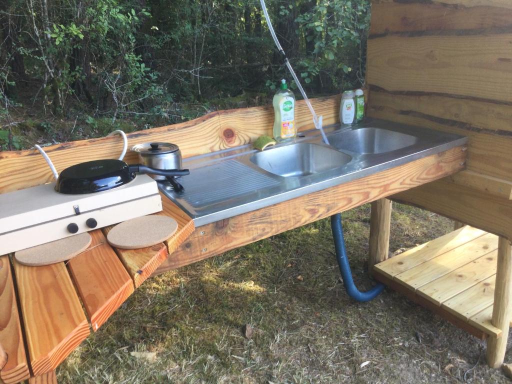 un évier de cuisine et un gril sur une table dans l'établissement La roulotte du bonheur, à Saint-Pardoux-la-Rivière