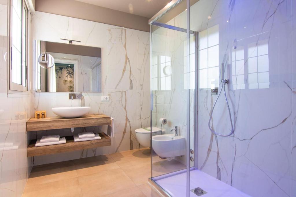 une salle de bain avec douche, lavabo et toilettes dans l'établissement Park Hotel Pineta Boutique Hotel, à Caorle