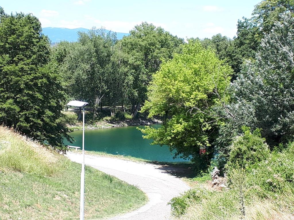 un chemin de terre à côté d'une rivière arborée dans l'établissement Camping Bois et Toilés, à Peyraud 34 autres photos