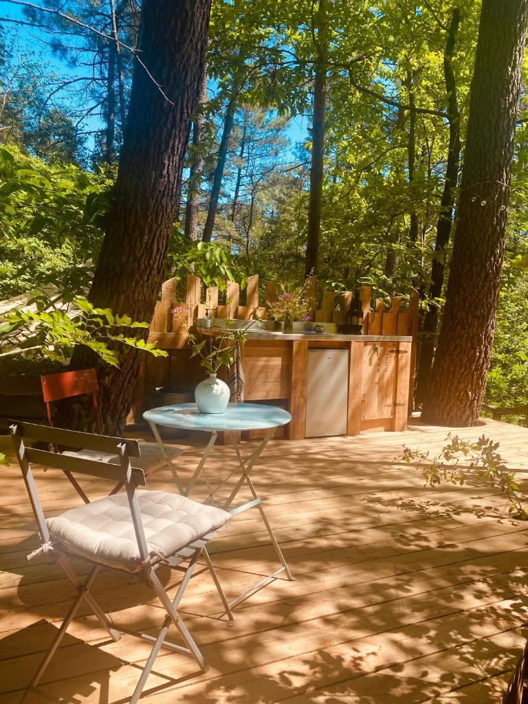 une table et une chaise sur un patio arboré dans l'établissement Tente Zina, à Chamborigaud