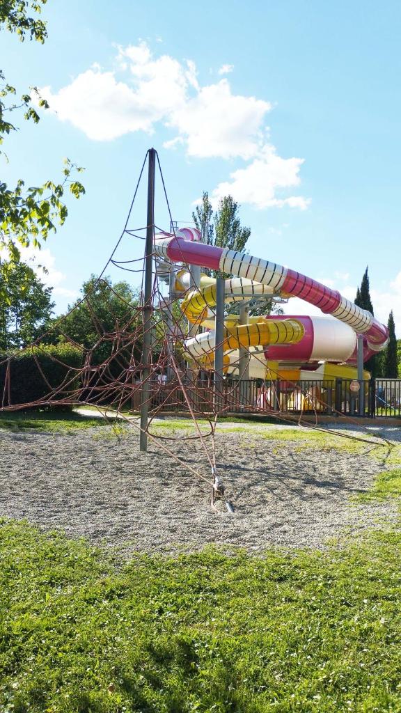 une aire de jeux avec un toboggan dans un parc dans l'établissement Mobil Home vue sur le lac dans un camping 4 étoiles à Cadenet, à Cadenet