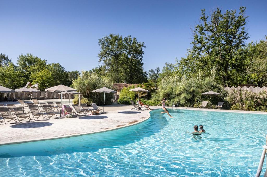 un groupe de personnes dans une piscine dans l'établissement Huttopia Lac de l'Uby - Gers, à Cazaubon