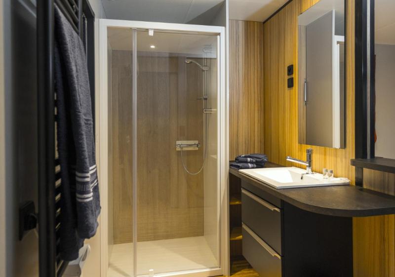 une salle de bain avec douche et lavabo dans l'établissement Camping Domaine Les Oréades - Maeva Sélection, à Sanguinet