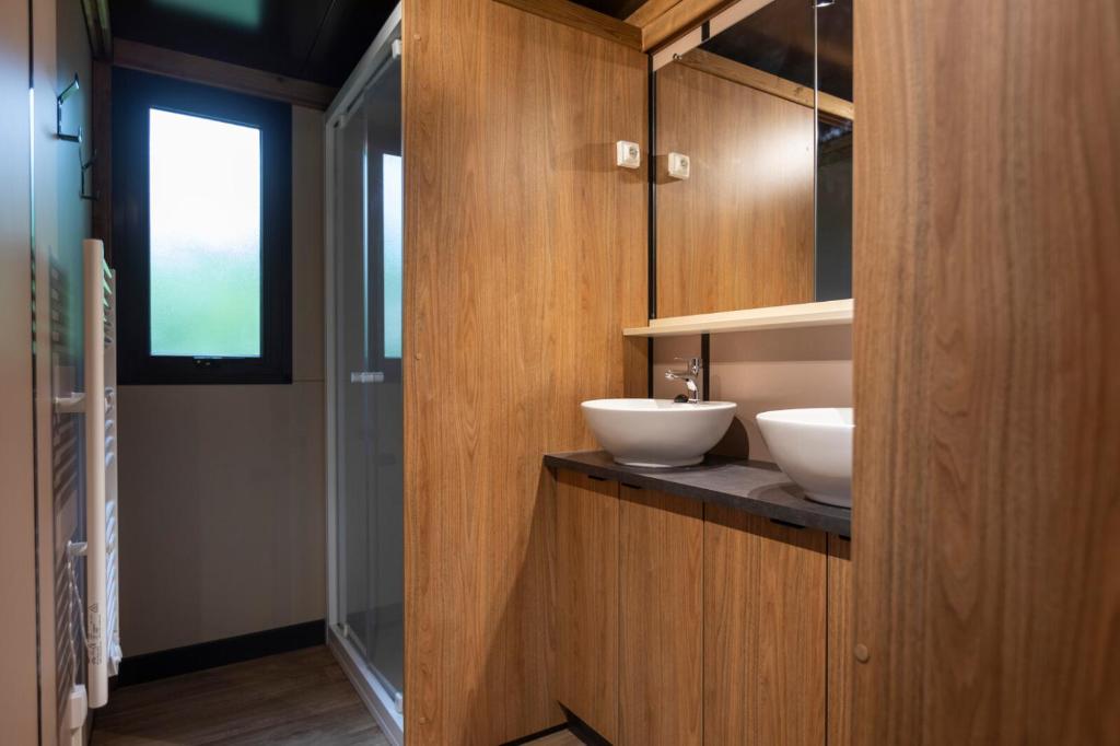 une salle de bain avec deux lavabos sur un comptoir dans l'établissement Huttopia Landes Sud, à Saint-Michel-Escalus 27 autres photos