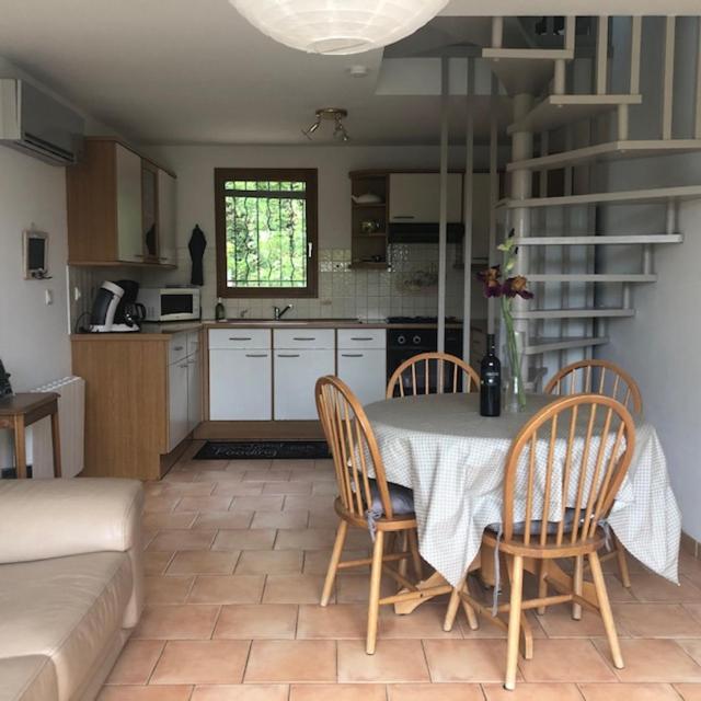 une cuisine avec une table et des chaises dans une cuisine dans l'établissement Gite l'Annexe, à Villelaure