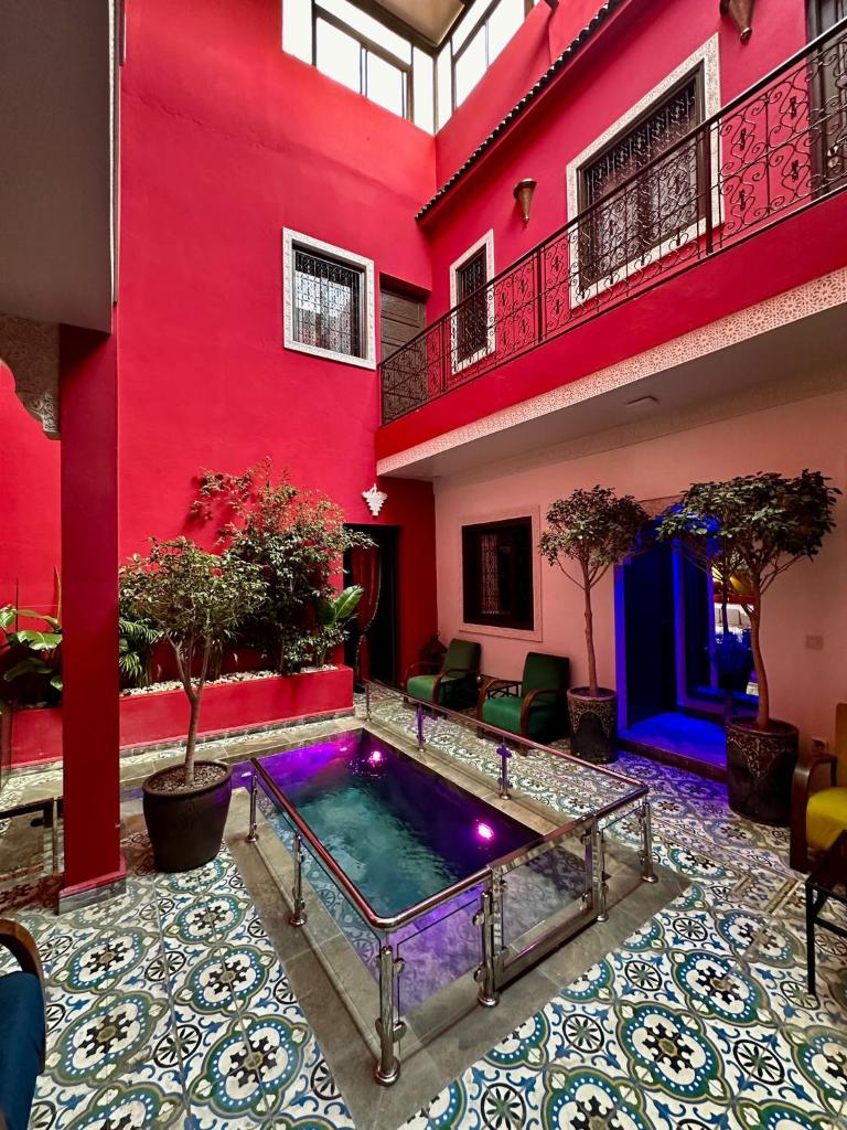 une piscine au milieu d'un bâtiment rouge dans l'établissement Riad Hilmuna Hammam et Spa, à Marrakech