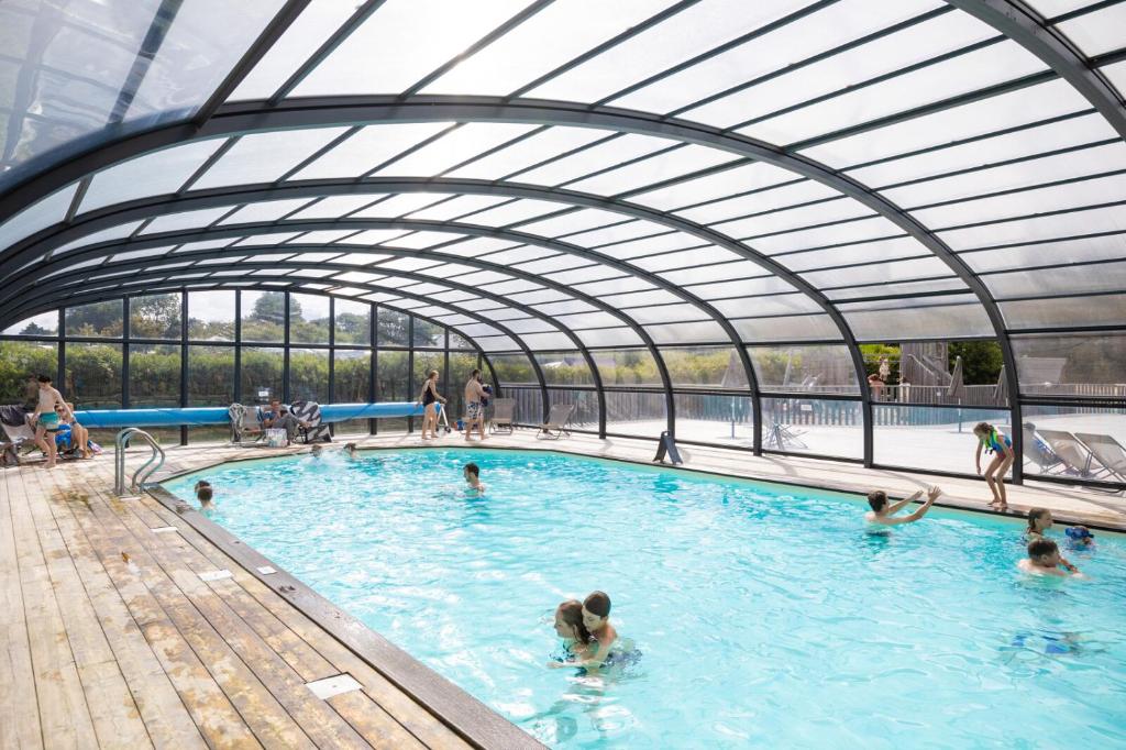 - une piscine avec des personnes à l'eau dans l'établissement Huttopia Les Falaises - Normandie, à Saint-Pierre-en-Port 28 autres photos