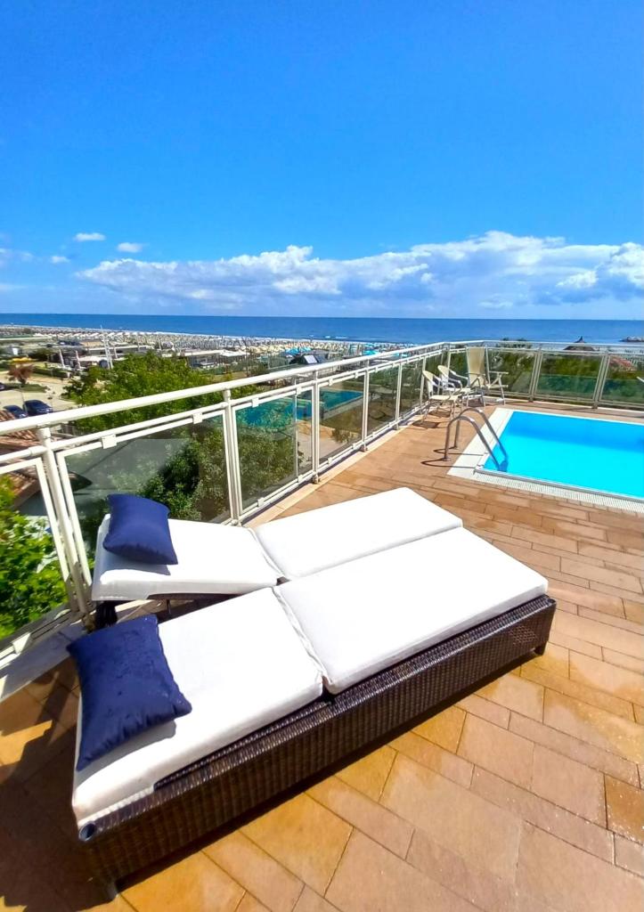 - un balcon avec 2 lits et une piscine dans l'établissement Hotel Ariella, à Milano Marittima