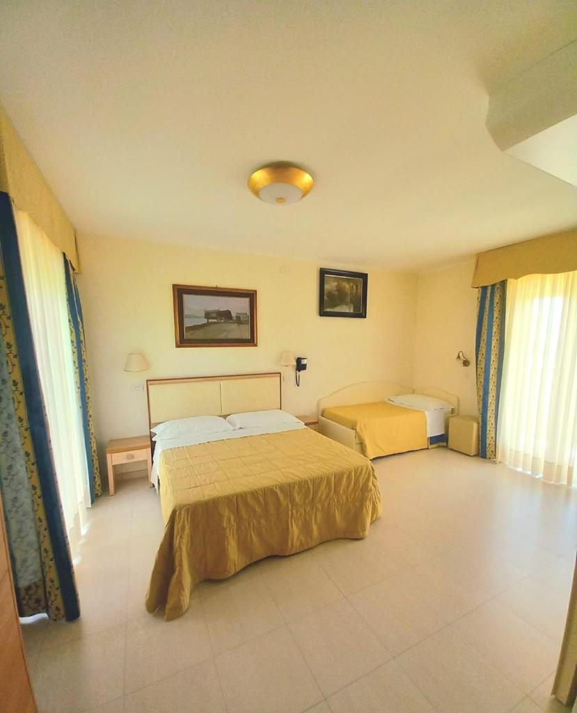 une chambre avec deux lits dans une pièce dans l'établissement Hotel Ariella, à Milano Marittima