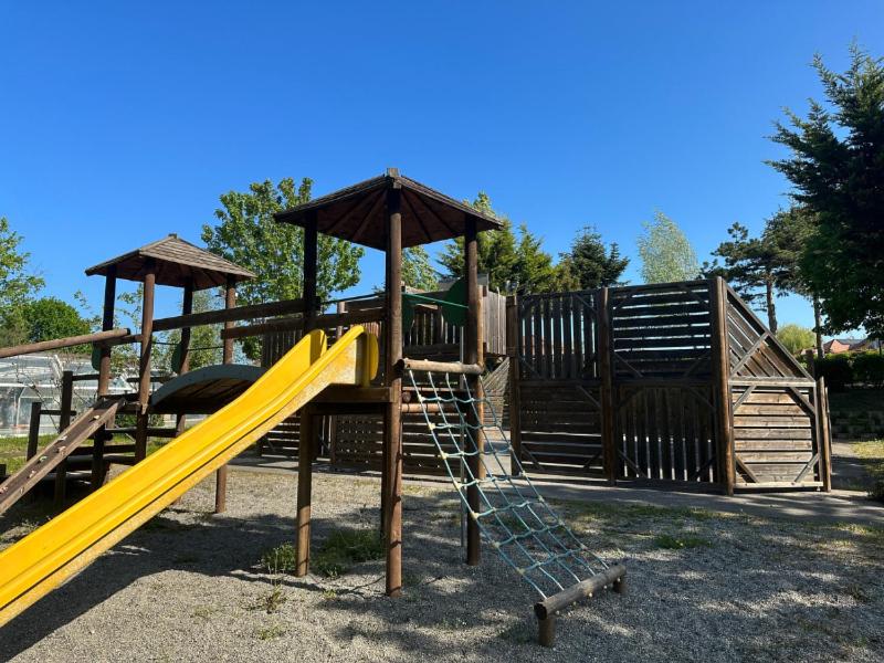 une aire de jeux avec toboggan jaune dans un parc dans l'établissement Camping le Relais du Léman, à Messery