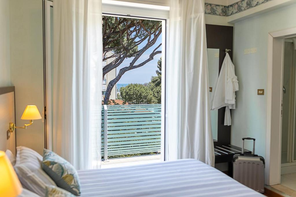 une chambre avec un lit et une fenêtre avec vue dans l'établissement Hotel Adriatica con Piscina, à Riccione