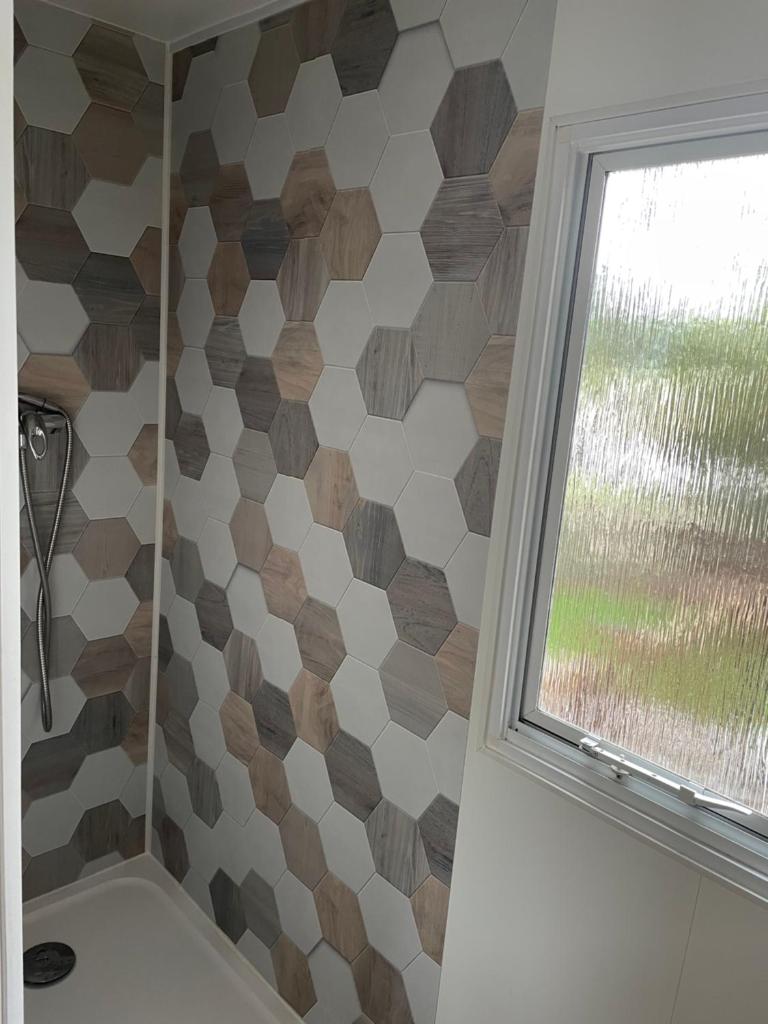 une salle de bain avec douche et fenêtre dans l'établissement Camping Oasis village, à Puget-sur Argens
