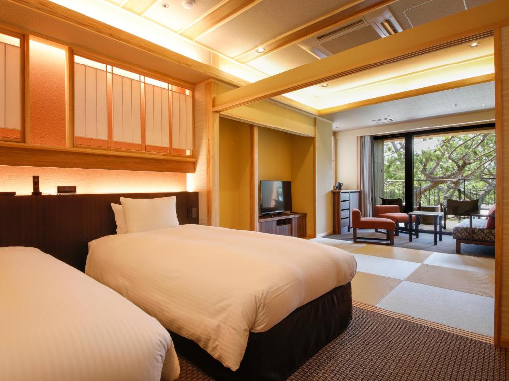 une chambre avec deux lits et un salon dans l'établissement Awaji Hamarikyu Takumi, à Minamiawaji